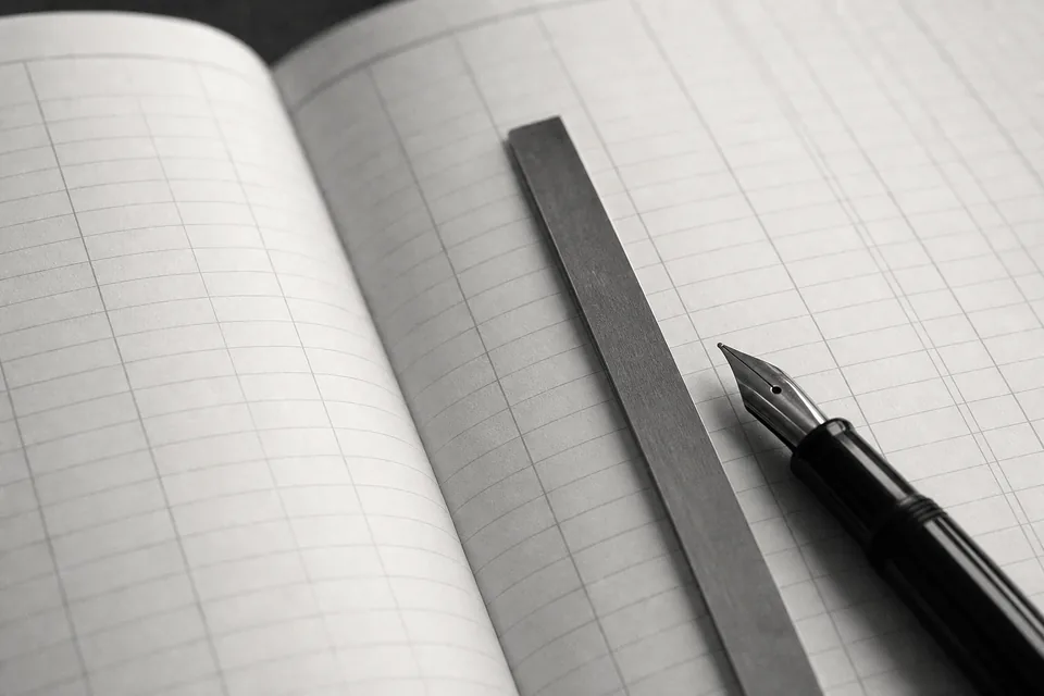 An open accounting ledger with a steel ruler and a fountain pen